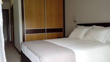 Ein Hotelzimmer mit einem Bett, einem Schrank und einem Nachttisch.