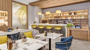A modern bar area with wooden shelves, bar stools, and a counter. - Protur Naisa Palma Hotel (Palma de Mallorca)
