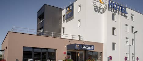 Un hotel moderno con un letrero que dice "ace HOTEL" y "l'Accueil".