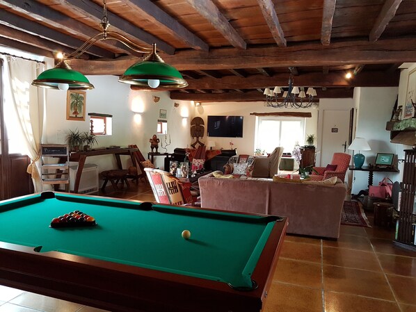 A cozy living room with a pool table, a sofa, and a dining area. - Domaine De Millox (Saint-André-de-Seignanx)