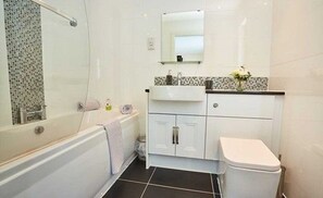 Une salle de bain avec une baignoire, des toilettes et un lavabo.