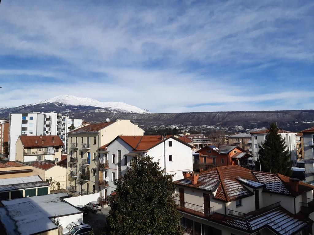 Un quartier résidentiel avec des immeubles et, en arrière-plan, une montagne enneigée.