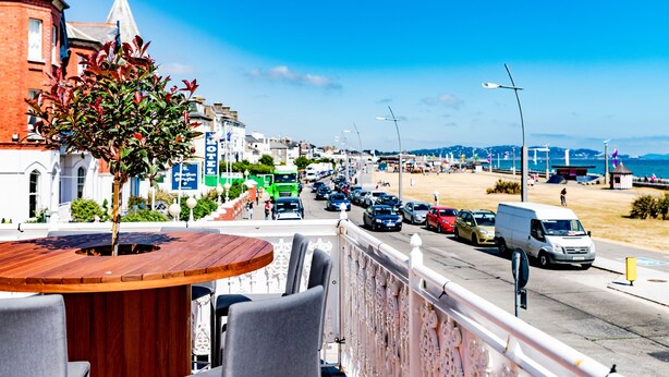 Hotel a la costa amb terrassa que faig vedar una avinguda animada i la platja.