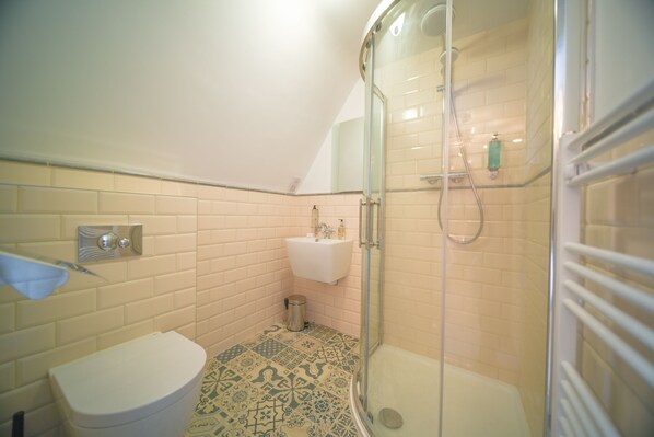 A bathroom with a toilet, sink, and shower. - The Strand Hotel, the former residence of Oscar Wilde (Bray)