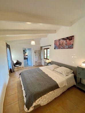 A bedroom with a bed, a nightstand, a chair, a desk, and a window. - B&B Le Mas de la Soie (Violes)