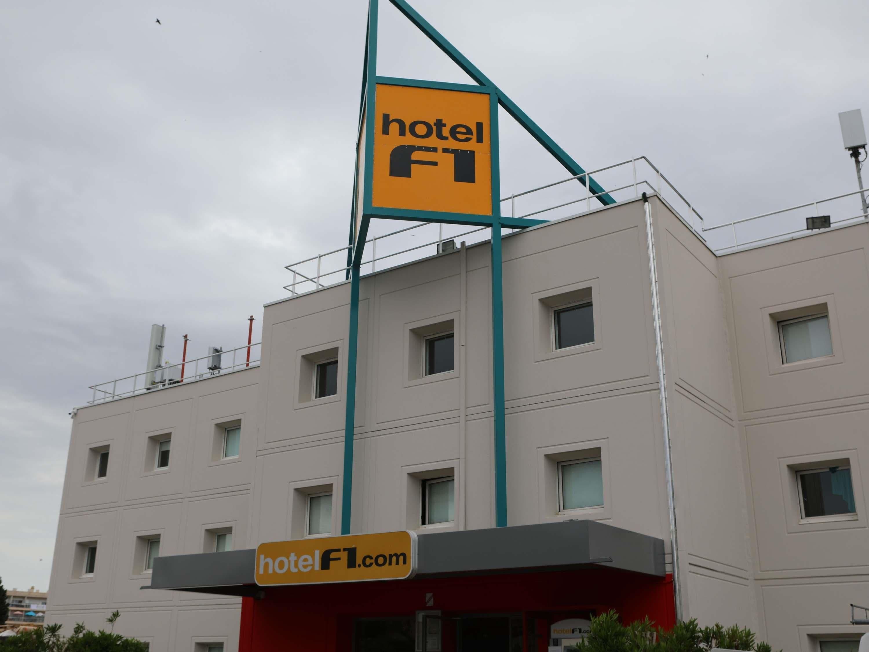 Un bâtiment d’hôtel avec une enseigne bien visible indiquant « hôtel » et une adresse de site web affichée.