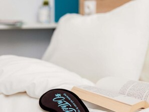 Een bed met een boek en een zwart voorwerp met tekst erop.