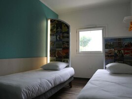 Una habitación con dos camas individuales, un ventanal con vistas y una pared decorada con carteles de viajes.