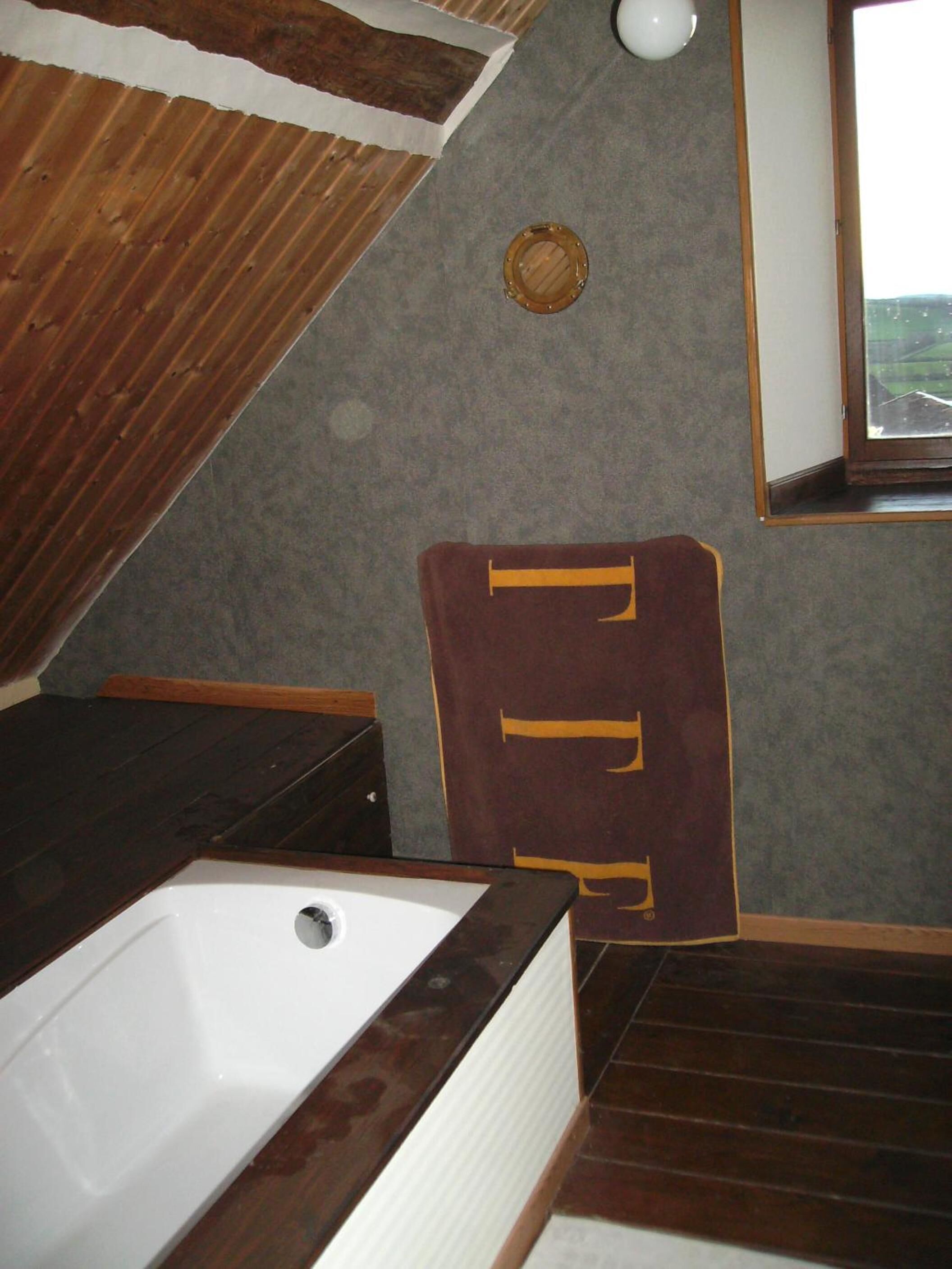 A bathroom with a wooden vanity, a bathtub, and a towel rack.