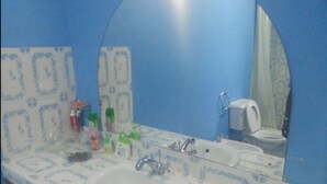A bathroom with a white sink, a mirror, and a toilet. - Coral Sea Villas (Malindi)