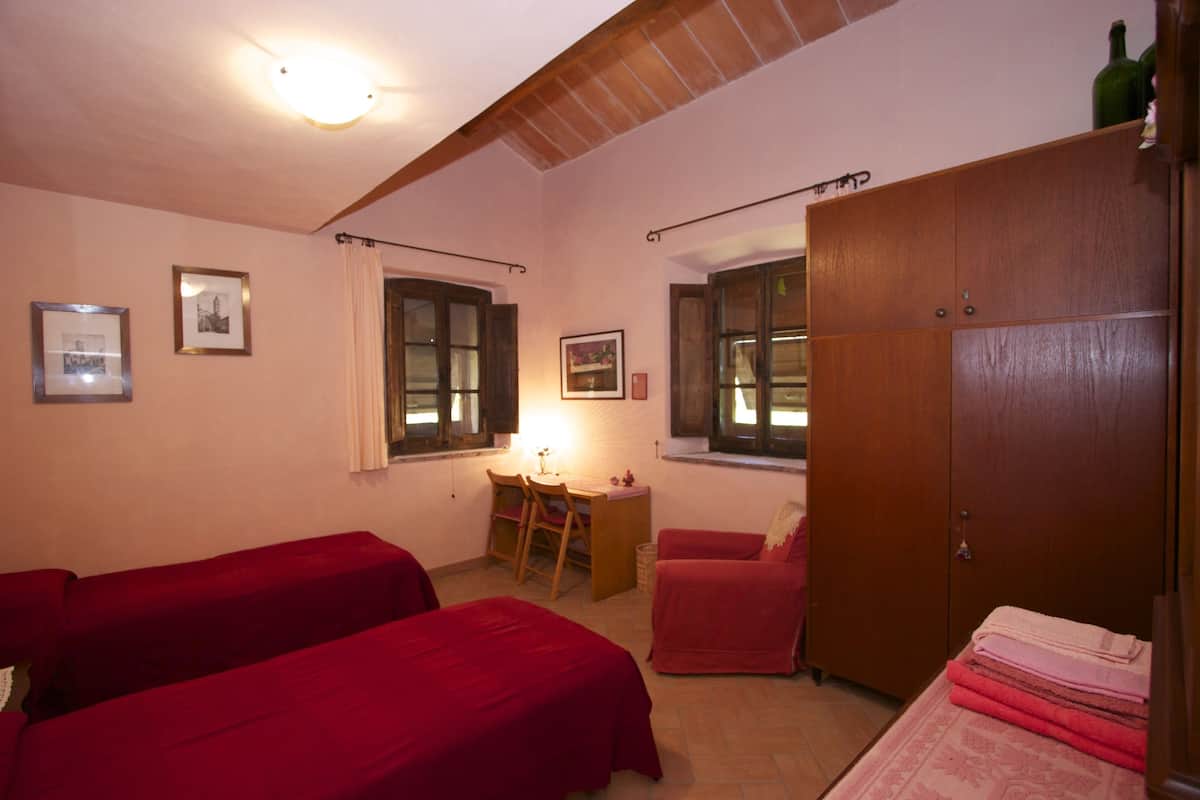 A room with two beds, a desk, and a wardrobe.