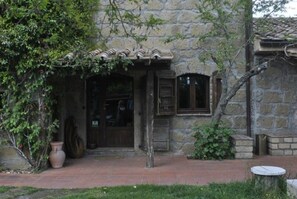 A rustic stone building with a tiled roof, a wooden door, and a small window. - Agriturismo Solidor (Pitigliano)