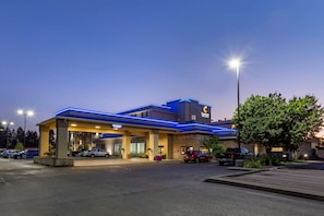A hotel with a blue roof and a sign that reads "Comfort Inn & Suites."