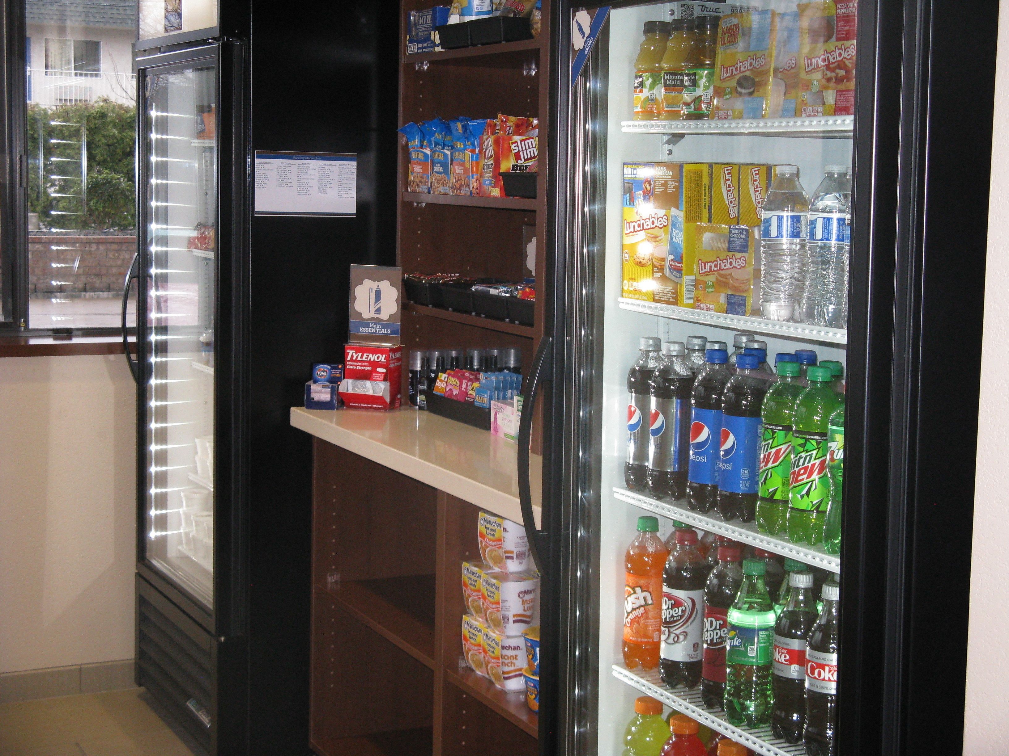Máquina expendedora llena de refrigerios y bebidas, incluyendo marcas populares como Pepsi y Mountain Dew.