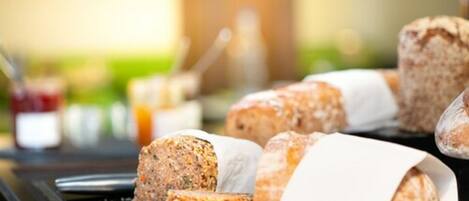 A selection of sliced meats and breads on a counter.