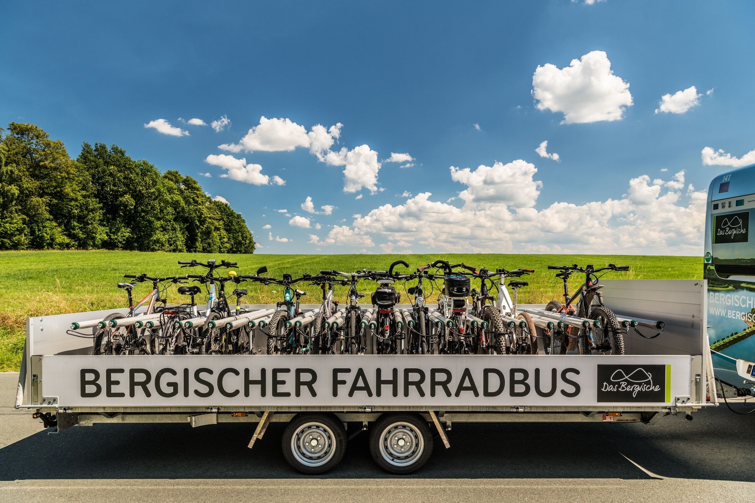 A trailer with the text "BERGISCHER FAHRRADBUS" and "Das Bergische" on it, carrying multiple bicycles.
