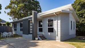 A single-story house with a front porch, a small staircase leading to the entrance, and a patio area with outdoor furniture. - Cowes Retreat - *Pet Friendly* Holiday House!!! (Cowes)