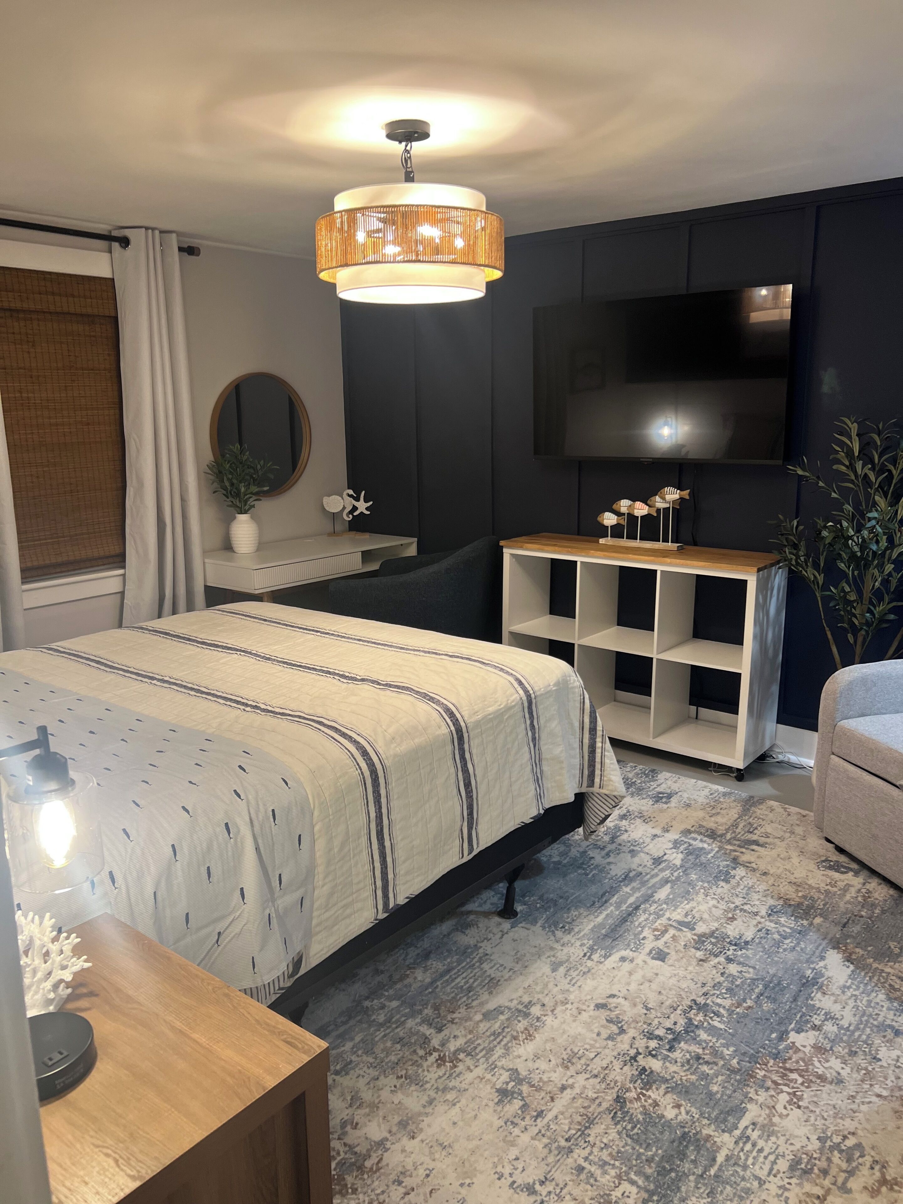 Ein modernes Schlafzimmer mit Bett, Nachttisch, Fernseher und integrierten Regalen.