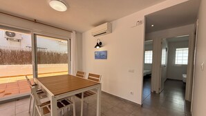 Ein Essbereich mit Tisch und Stühlen, einer Klimaanlage, einer Deckenleuchte und einem Fenster mit Blick.