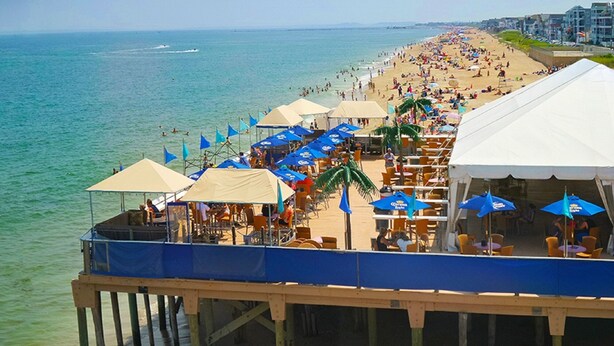 A beachside restaurant with outdoor seating, a pier, and a view of the ocean. - Ocean wave, Salisbury Beach, Melo's Beach House rentals (Salisbury)