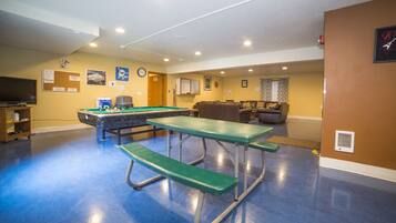 Enjoy leisure activities in this room featuring a pool table, billiards table, and TV for entertainment.