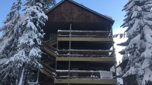 Un bâtiment à plusieurs étages, avec une façade en bois, un balcon au deuxième étage et une enseigne indiquant qu’il s’agit d’une salle de jeux pour les conférences.