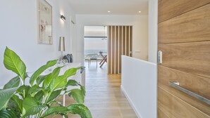 Ein moderner Flur mit einer Holzwandverkleidung, einem Blumentopf und einem gerahmten Bild.