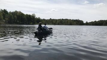 A calm lake with a boat carrying two people.