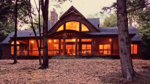 A lodge with a prominent central entrance, large windows, and a symmetrical roofline.