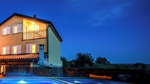 Un edificio de dos pisos con una piscina frente a él.