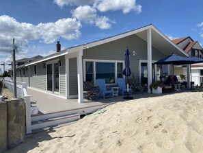 A beachfront house with a covered patio, outdoor seating, and a view of the ocean. - Beachfront Oasis, Seabrook, NH - One step to the beach! (Seabrook)