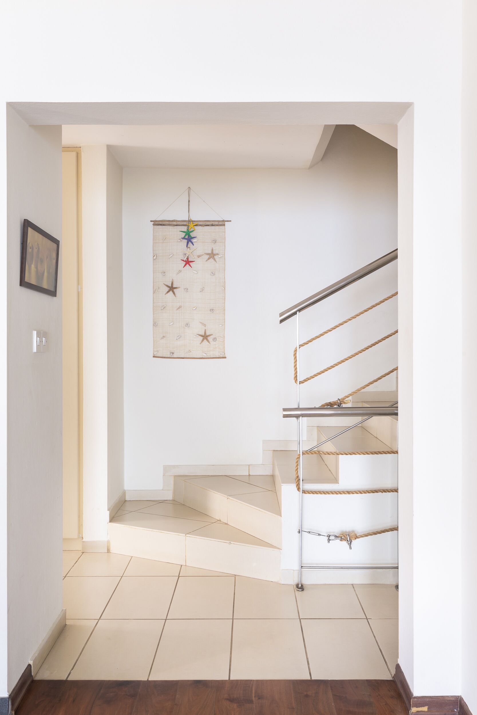 Una escalera con barandilla de metal y una barrera de cuerda.