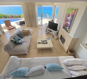 TV connectée, cheminée, livres, chaîne hi-fi