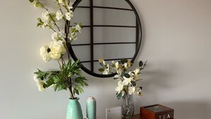 A wooden console table with a vase of white flowers, a teal vase, a white device, and a wooden box labeled "TEA". - Luxurious with great city views, free Private parking & fast internet  (South Yarra)