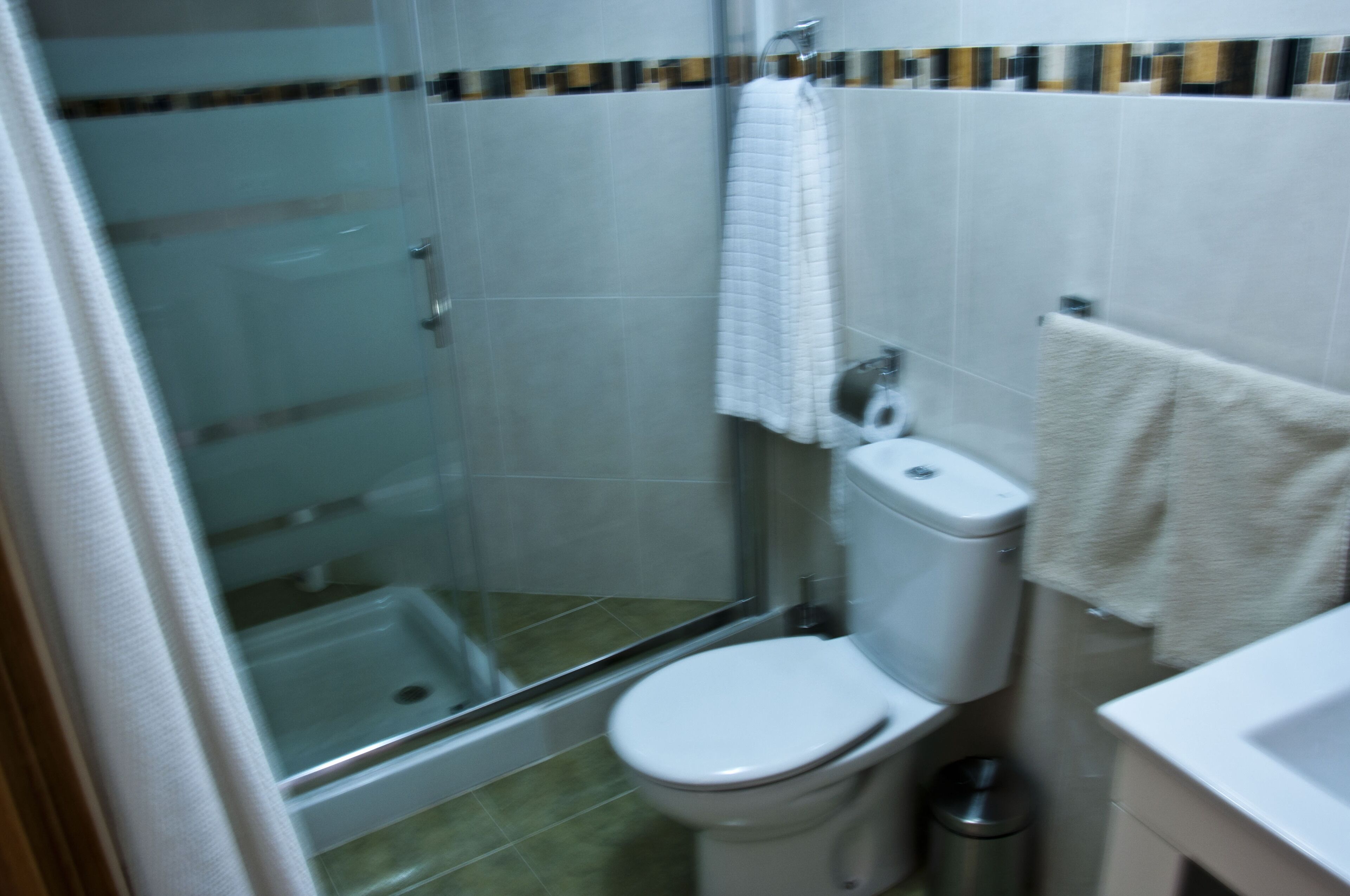 Ein Badezimmer mit Duschkabine, Toilette und Waschbecken.