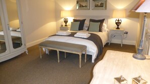 A neatly arranged bedroom with a large bed, bedside tables, a bench, and a mirror. - Award Winning Ideal Rural Escape in Earn Valley 5 min from Perth (Perth)