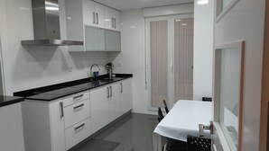 A modern kitchen with white cabinets, a black countertop, and a stainless steel range hood. - FULL CENTER REFURBISHED 6 SEATS WIFI. 3 MINUTES FROM LAUREL STREET WALKING (Logroño)
