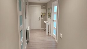 A narrow hallway with a radiator, a door at the end, and a small table with magazines. - FULL CENTER REFURBISHED 6 SEATS WIFI. 3 MINUTES FROM LAUREL STREET WALKING (Logroño)