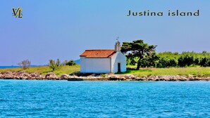 Un petit bâtiment blanc, surmonté d’un toit rouge, situé sur une île côtière.
