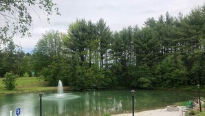 Ein ruhiger Park mit einem Brunnen, einem Kiesweg und einer Sitzgelegenheit.