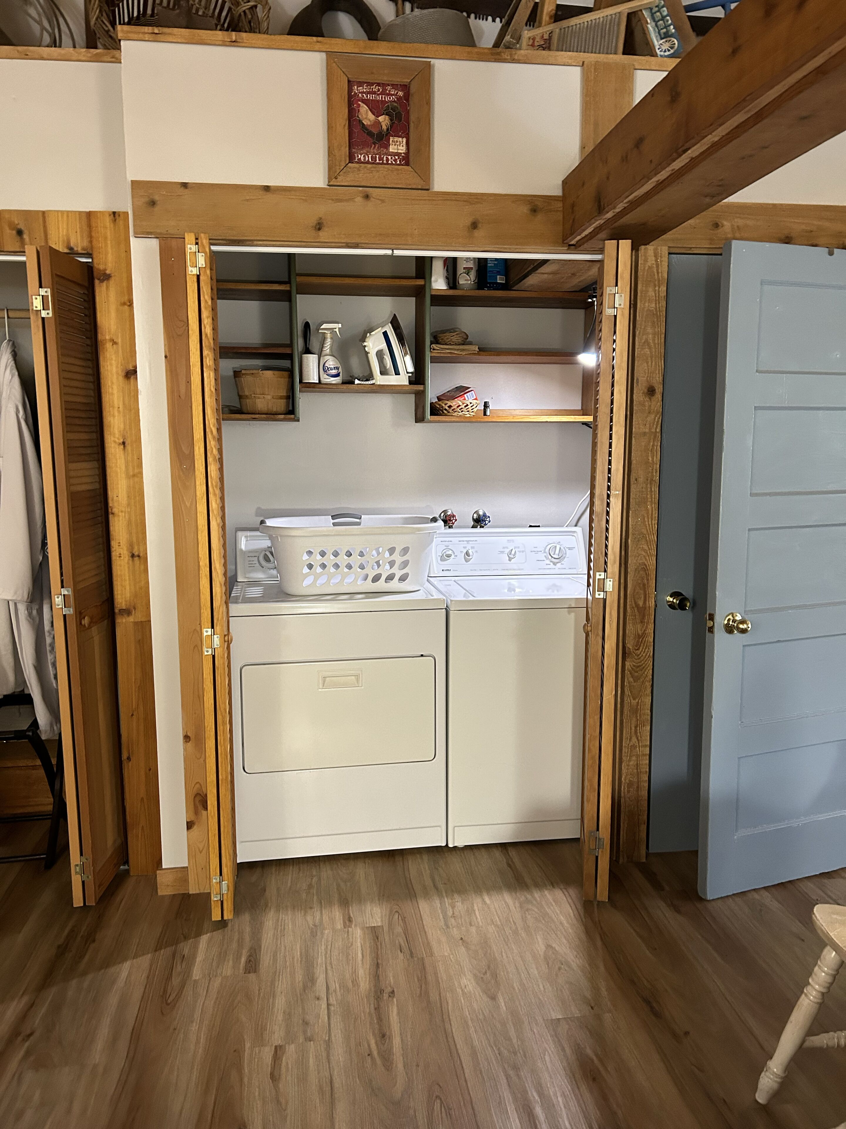Una cucina funzionale con piano cottura integrato, lavatrice e mensole in legno.
