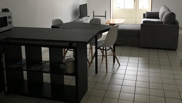 Un salon moderne avec une table à manger, un canapé et un téléviseur.