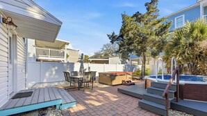 Ein Garten mit Whirlpool, Gartenmöbeln und einer Holzterrasse.