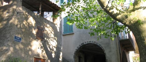 A stone building with a wooden door and a sign that reads "Place Bouget de L'Isle".