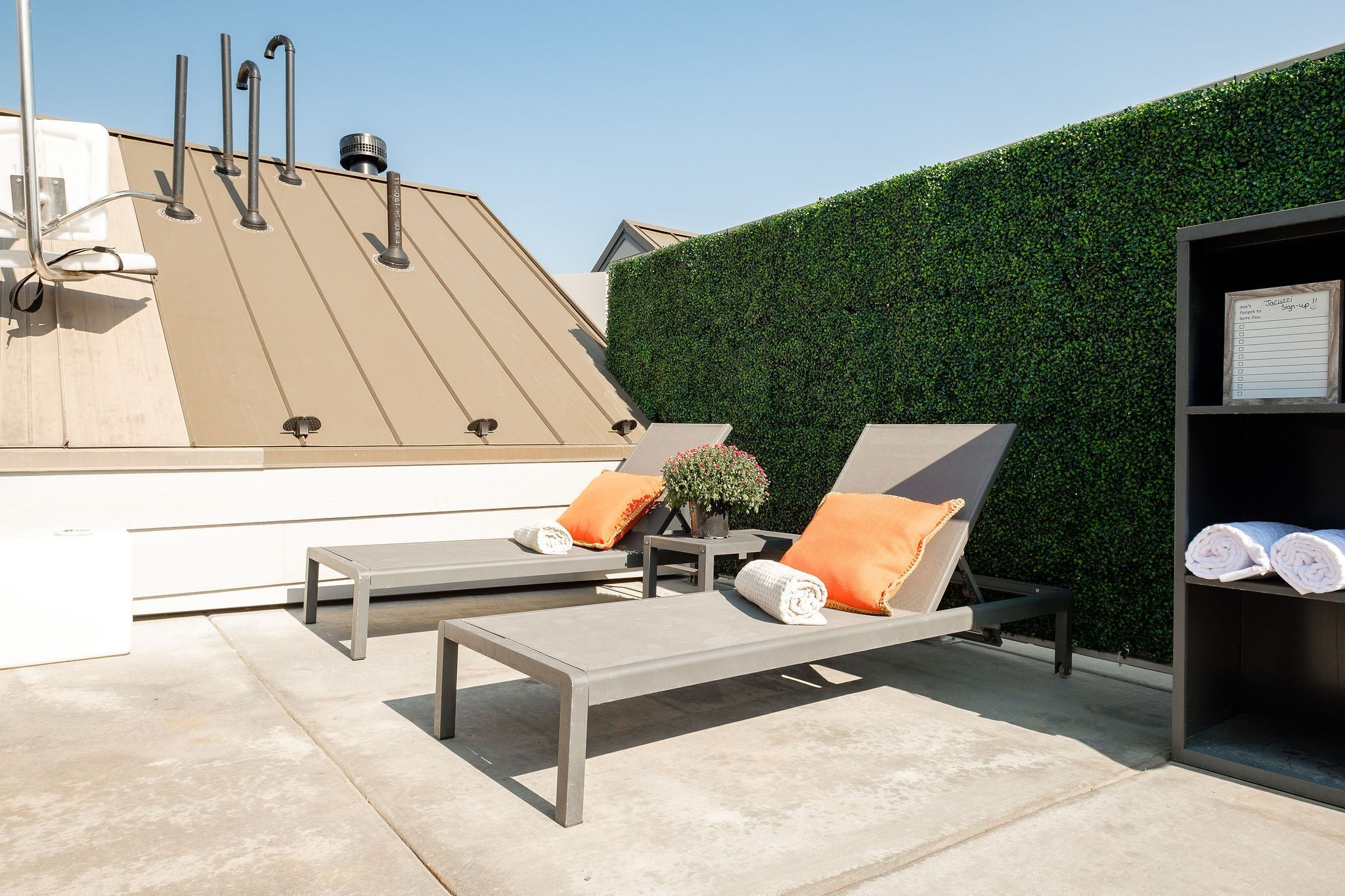 Una terraza en la azotea con dos sillones de descanso, una mesita y un calentador de pared.