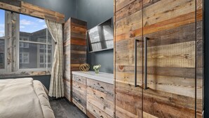 A bedroom with a large window, wooden wardrobe, and a bedside table with a vase. - Ski In/Out and on Main Street! It Doesn't Get Any Better! (Park City)