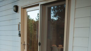 A house with a sliding glass door, a concrete porch, and a doormat with text. - The Bright Boho-Tel  (Flagstaff)