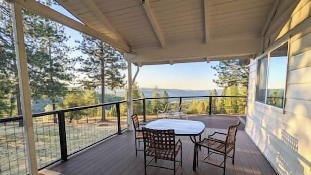 A covered outdoor area with a table and chairs, overlooking a forested landscape. - Kirkwood Ski, Wineries, Caves, Family friendly, near Gold Country (Volcano)