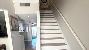 A staircase with wooden steps and white risers, leading to an upper floor.