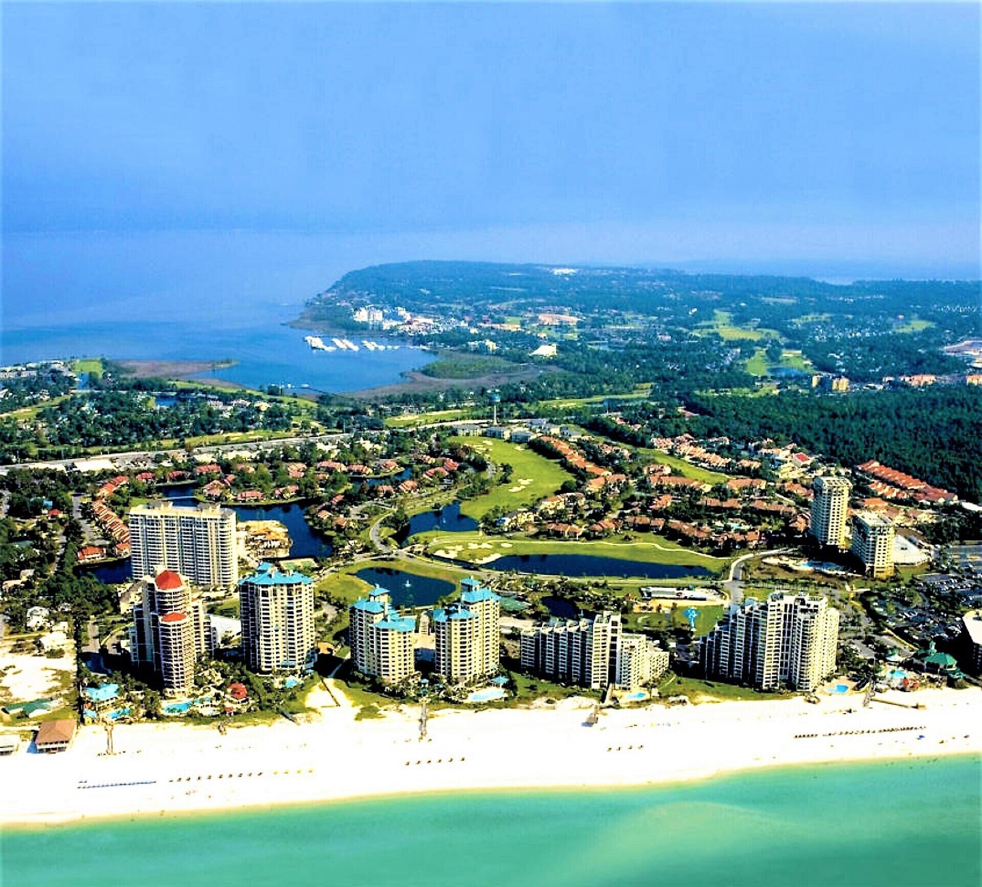 Une station balnéaire dotée d’immeubles de grande hauteur, d’un terrain de golf et d’une plage.